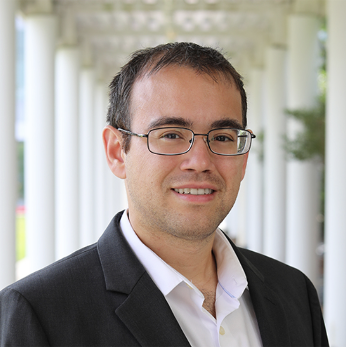 man with glasses wearing a suit and smiling